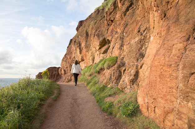 Walker on Giants Causeway Coastal Footpath, County Antrim, Irlanda do Norte, Europa