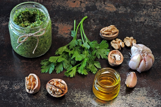 Walnusspesto mit Petersilie. Hausgemachte Pesto-Sauce in einem Glas. Draufsicht. Veganes Pesto mit Walnuss und Petersilie.