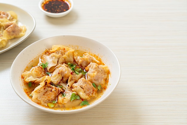 Wan-Tan-Suppe mit Schweinefleisch oder Knödelsuppe mit geröstetem Chili - asiatische Küche