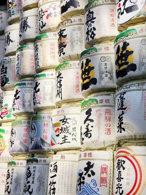 Wand aus großen Sake-Dosen mit japanischen Schriftzeichen in Tokio, Japan