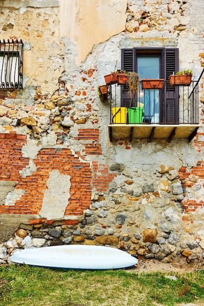 Wand des alten Gebäudes am Meer und kleines Boot in Cefalu, Sizilien, Italien