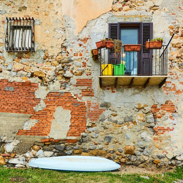 Wand des alten Gebäudes am Meer und kleines Boot n Cefalu, Sizilien, Italien