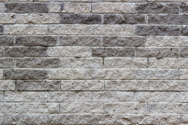 Wandbeschaffenheit aus grauen Steinziegeln. Abstrakter Steinziegelsteinhintergrund