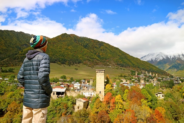 Wanderer beeindruckt durch Panoramablick von Mestia-Stadt mit Svan-Turm unter Herbstlaub, Georgia