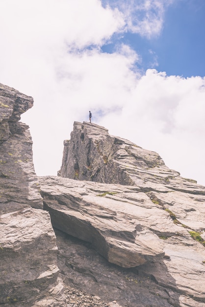 Wanderer, der auf Bergspitze, getontes Bild steht