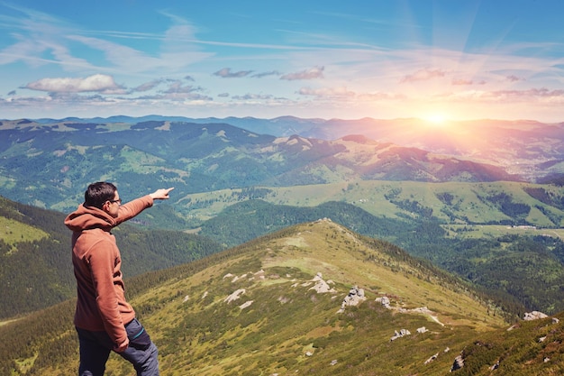 Wanderer, der auf einer Klippe steht Die Spitze des Berges