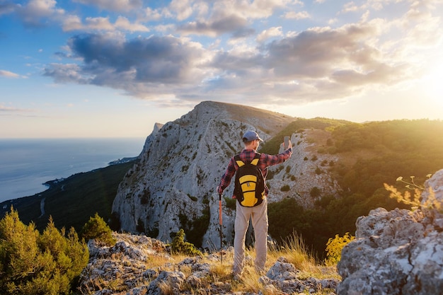 Wanderer des starken Mannes, der Foto mit intelligentem Telefon am Berggipfel macht