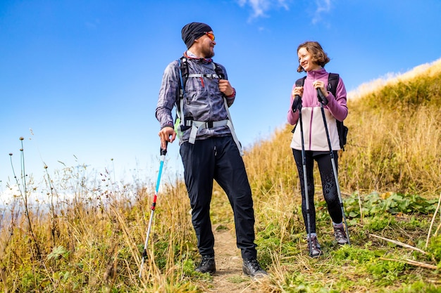 Wanderer heiraten mit Rucksäcken, die sich in den Flitterwochen auf einem Berg entspannen