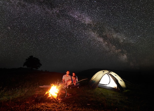 Wanderer in der Nähe von Lagerfeuer und Touristenzelt in der Nacht