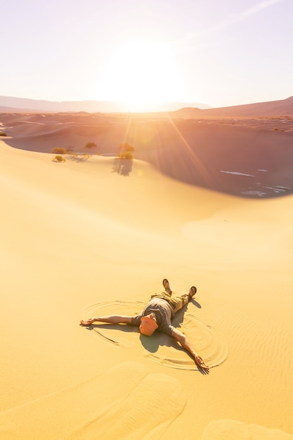 Wanderer in der Sandwüste. Sonnenaufgangszeit.