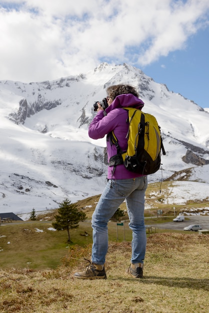Wanderer mit Kamera und Rucksack fotografieren schönen Berg