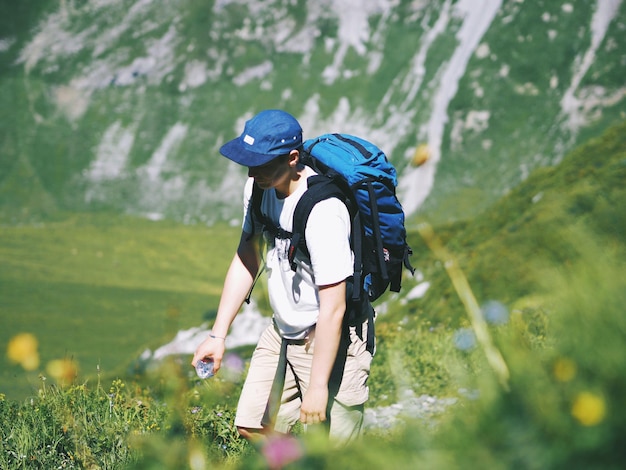 Wanderer mit Rucksack auf dem Feld gegen den Berg