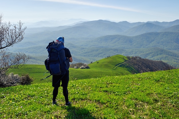 Foto wanderer mit rucksack auf einem berg entspannen und den blick ins tal genießen