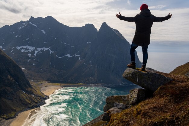 Wanderer mit Rucksack genießen die Sonnenuntergangslandschaft auf den Lofoten Norwegen