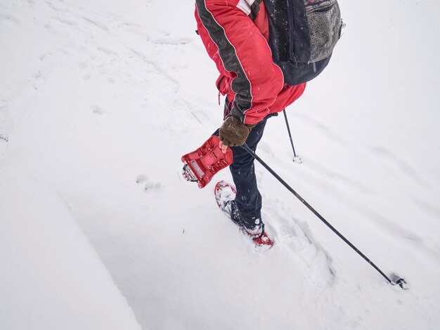 Wanderer mit Schneeschuhen und technischer Outdoor-Kleidung für Bergwanderungen im Schnee