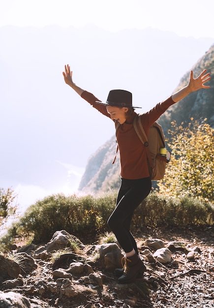 Wanderermädchen mit Rucksack auf dem Berg Frau, die während der Herbstsaison im Freien Urlaub macht