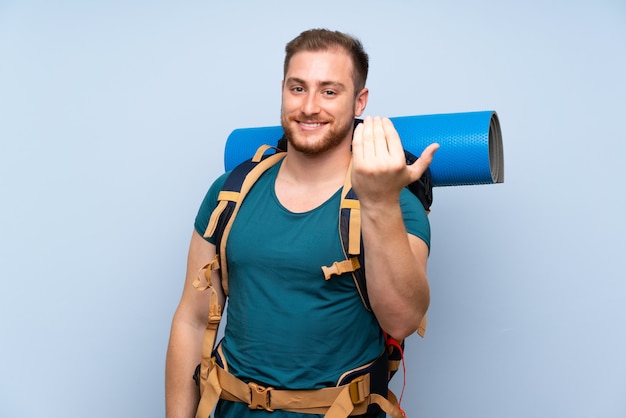 Wanderermann über der blauen Wand, die einlädt, mit der Hand zu kommen. Schön, dass Sie gekommen sind