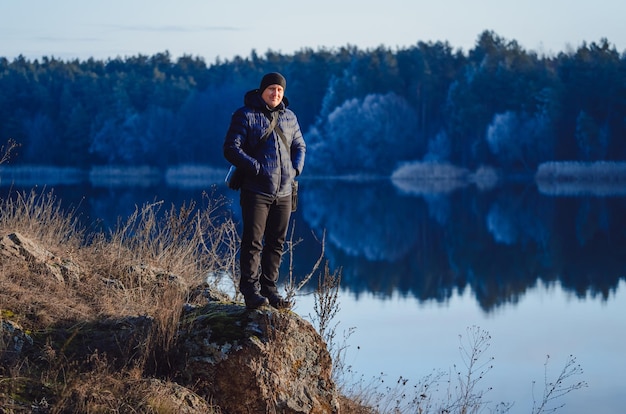 Wanderfotograf, der sich darauf vorbereitet, ein Bild der morgendlichen Landschaft in den Herbstbergen zu machen Mann, der den Ort mit Vergnügen betrachtet