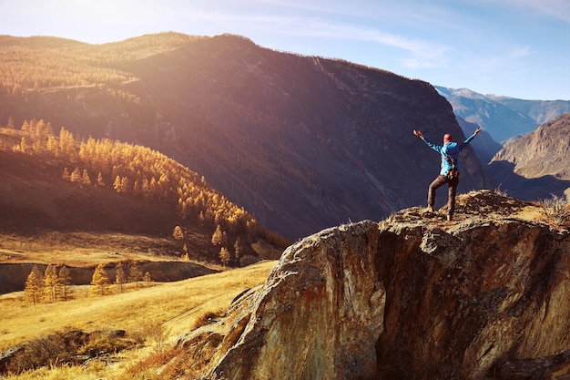 Wanderfrau mit Rucksack auf Felsen eines Berges und Sonnenaufgang genießen Reise-Lifestyle-Erfolgskonzept Abenteuer aktiver Urlaub Outdoor-Bergsport