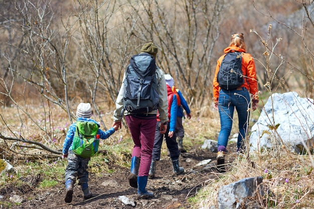 Wanderkinder mit Rucksäcken Touristengruppe zu Fuß auf einem Waldweg