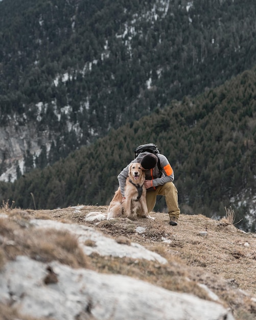 Wandermann mit seinem Golden Retriever-Hund im Berg