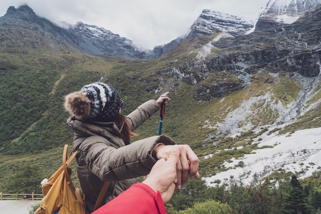 Wandern des jungen Paarreisenden, der schöne Landschaft Yading-Naturreservat betrachtet