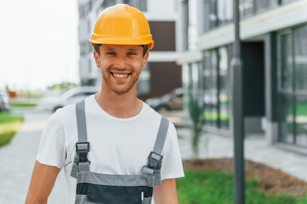 Wandern im Freien Junger Mann, der tagsüber in Uniform auf dem Bau arbeitet