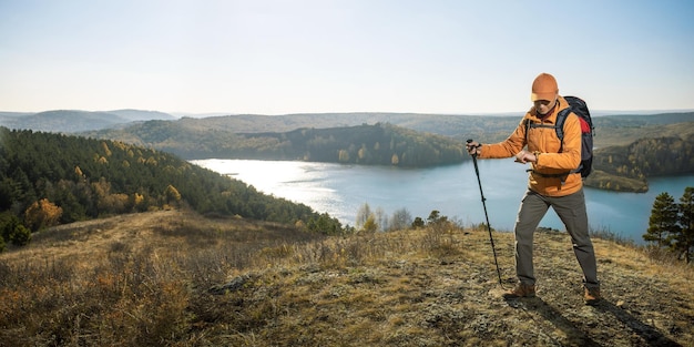 Wandern in den Bergen Wanderer mit Rucksack und Kompass auf dem Gipfel des Berges bei Sonnenuntergang Banner mit Kopierbereich