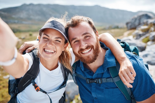 Wandern Selfie und Liebe mit einem Paar in den Bergen für Fitness-Übungen oder Abenteuer zusammen Portrait Natur und Bindung mit einem Mann und einer Frau, die im Freien auf einem natürlichen Bergpfad spazieren gehen