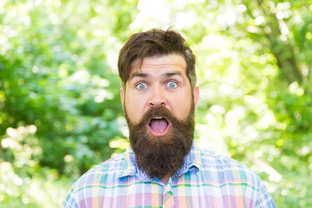 Wandern und reisen. Guy entspannen Sie sich in der Sommernatur. Vereint mit der Umwelt. Gut aussehender Holzfäller. Mann Bart und Schnurrbart im Sommerwald. Sommerferienkonzept. Mann bärtiger Hippie grüne Bäume Hintergrund.