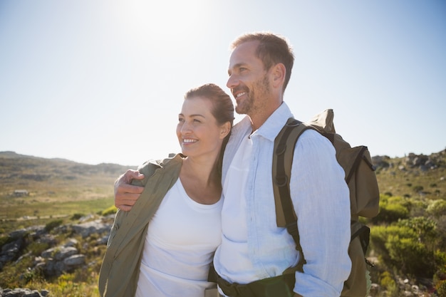 Wandern von den Paaren, die auf Landgelände umfassen und lächeln