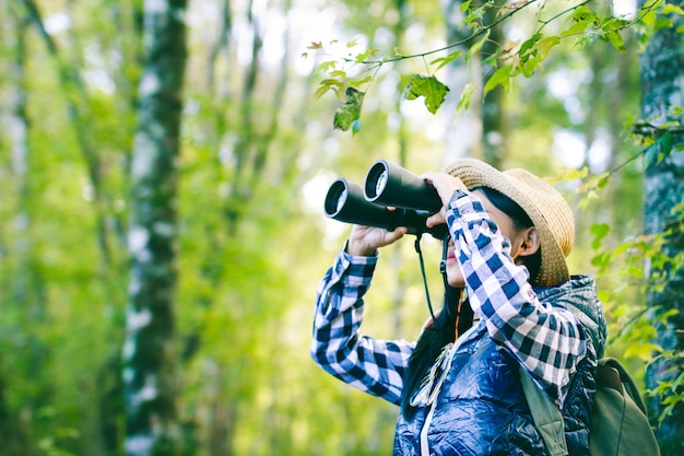 Wandernde Frauen erforschen den Wald mit Ferngläsern.