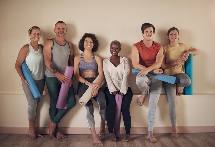 Foto wandgruppe und freunde für entspannung in der yoga-klasse aktive kleidung und lächeln für fitness im wellness-center workout porträt und training im studio für flexibilität pilates und gesundheit und ganzheitliches hobby
