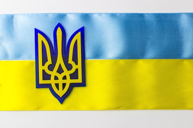 Wappen der Ukraine auf dem Hintergrund der Flagge Flagge von blauen und gelben Streifen