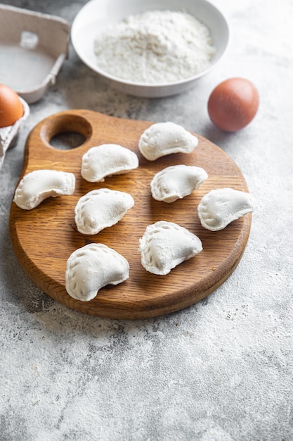 Wareniki rohe gefüllte Knödel, die bereit sind, einen Essenssnack auf dem Tisch zuzubereiten