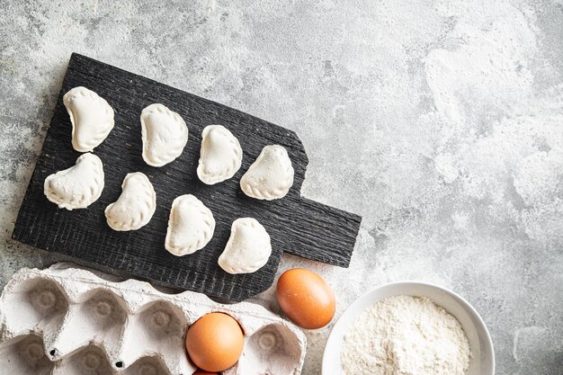 Wareniki rohe gefüllte Knödel, die bereit sind, einen Essenssnack auf dem Tisch zuzubereiten