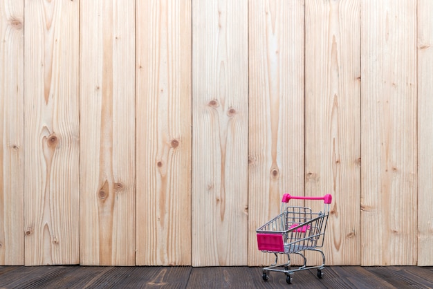 Warenkorb oder Supermarktlaufkatze auf Holztisch