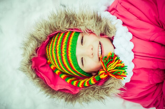 Warm Mädchen im Schnee liegen