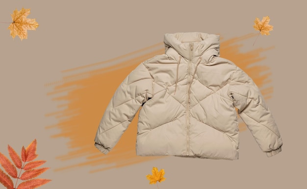 Warme beige Kapuzenjacke auf abstraktem Herbsthintergrund Das Konzept warmer Kleidung für die kalte Jahreszeit