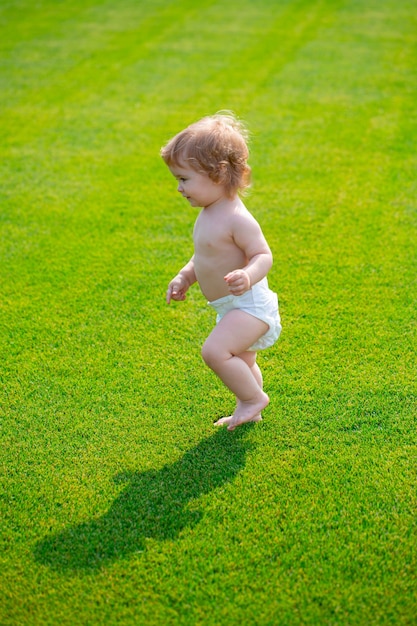 Warme Frühlingszeit im Parkbaby im schönen Frühlingsgrünfeld erster Schritt