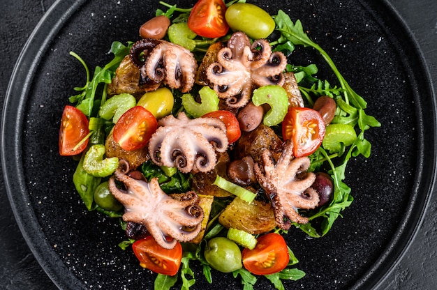 Warmer Salat mit Tintenfisch, Kartoffeln, Rucola, Tomaten und Oliven.