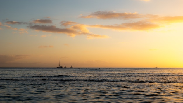 Warmer sonnenuntergang auf dem meer mit segelbooten am horizont