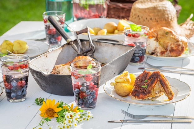 Warmes Abendessen mit Huhn und Kartoffeln im Garten serviert