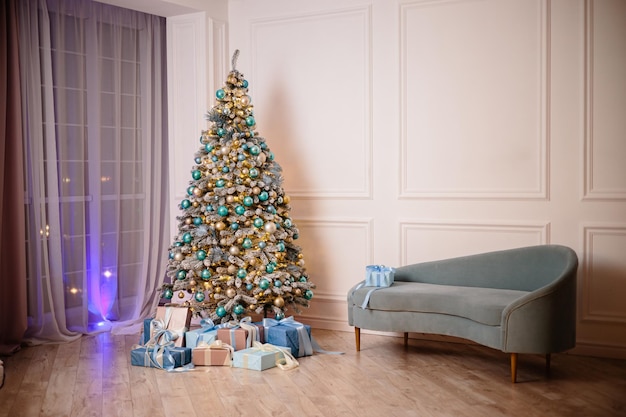 Warmes gemütliches schönes modernes Zimmerdesign in sanften hellen Farben dekoriert mit einem Weihnachtsbaum und Dekoelementen für das neue Jahr