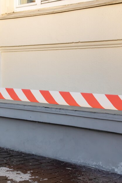 Warnendes rotes und weißes Klebeband gegen die Wand