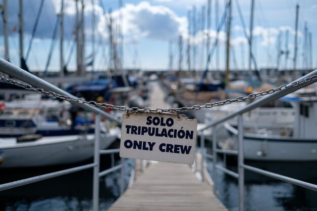 Foto warnschild, das an der anlegestelle an booten hängt, die am hafen verankert sind