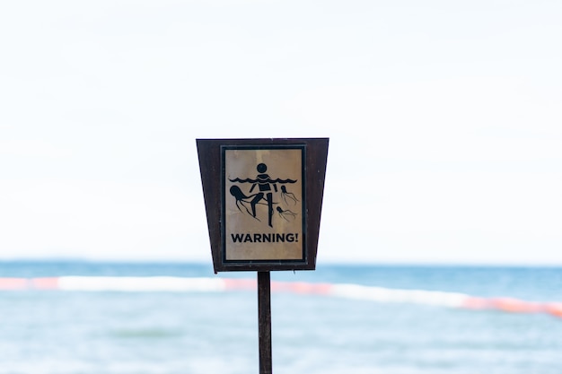 Warnschild, Vorsicht vor Quallen am Strand.