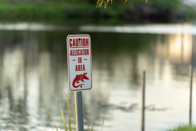 Warnzeichen für Alligatoren in einem Park in Florida über Vorsicht und Sicherheit beim Gehen in der Nähe von Wasser