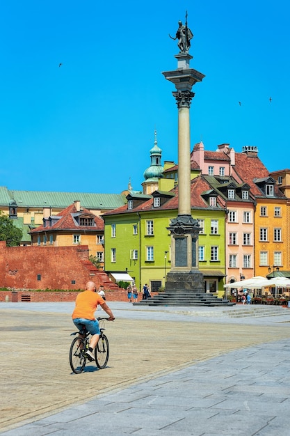 Warschau, Polen - 30. Juli 2018: Mann mit dem Fahrrad an der Sigismundsäule auf dem Schlossplatz in der Altstadt von Warschau in Polen