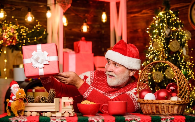 Was für eine süße Kiste. Weihnachtskomposition. bereit für die Silvesterparty. bärtiger Mann isst Kekse. Winterurlaubsstimmung. Weihnachtsfeier feiern. Opa trinkt Milch. Santa zu Abend essen. für den Weihnachtsmann.